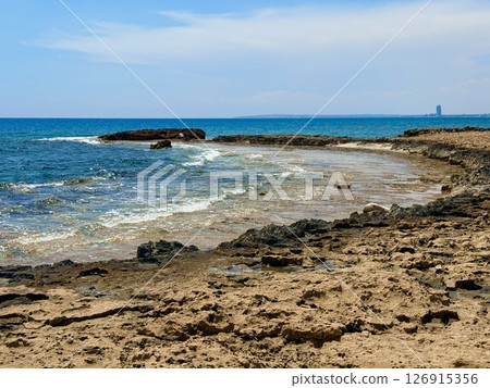 Picturesque beach, waves crashing on the sandy shore. Sea waves beat against the rocks. Cyprus Island, Mediterranean Sea. Picturesque beach, waves crashing on the sandy shore. Sea waves beat against the rocks. Cyprus Island, Mediterranean Sea. 126915356