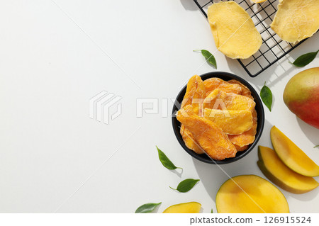 A bowl of dried mango chips with fresh sliced mango A bowl of dried mango chips with fresh sliced mango 126915524