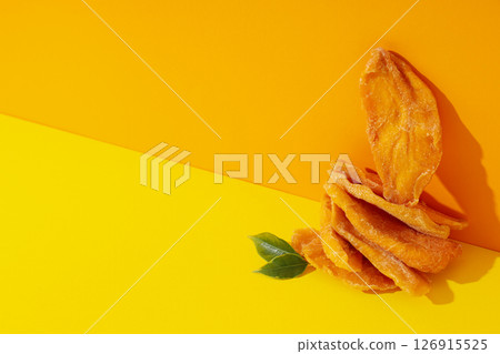 Dried mango chips on a yellow background 126915525