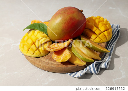Fresh and dried mangoes on a wooden board 126915532