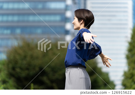 A woman stretching with a cityscape in the background A woman stretching with a cityscape in the background 126915622