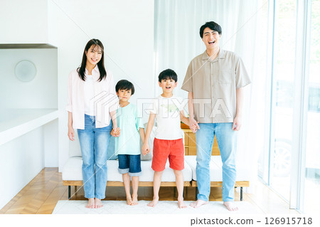 Family standing side by side in the living room 126915718