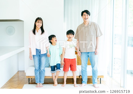Family standing side by side in the living room 126915719