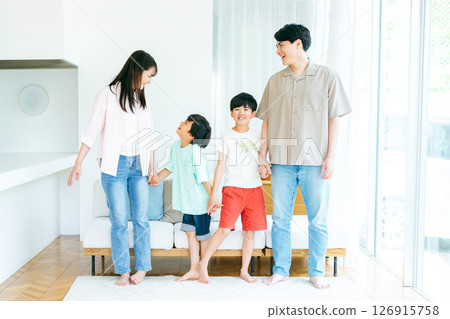 Family standing side by side in the living room 126915758