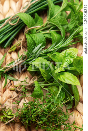 Freshly picked herbs displayed on a woven tray, a culinary delight Freshly picked herbs displayed on a woven tray, a culinary delight 126916252