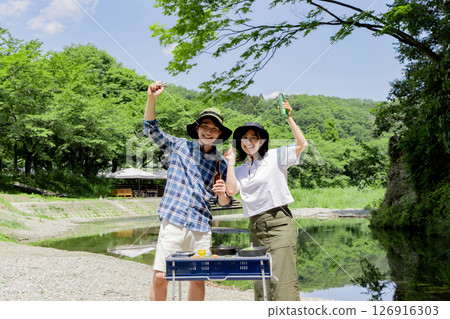 Young people enjoying outdoor activities on the riverbank 126916303