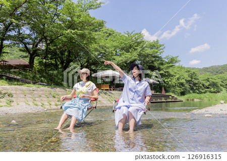 Camping: Woman dipping her feet in the river 126916315