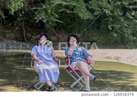 露營夫婦把腳浸入河中 露營夫婦把腳浸入河中 126916374