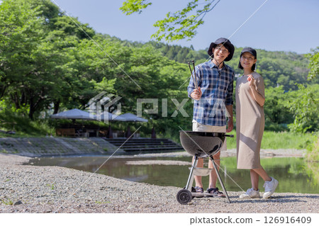 Young people enjoying outdoor activities on the riverbank 126916409