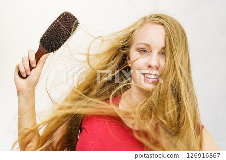 Blonde girl long blowing hair holds natural bristles brush Blonde girl long blowing hair holds natural bristles brush 126916867