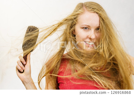 Blonde girl long blowing hair holds natural bristles brush Blonde girl long blowing hair holds natural bristles brush 126916868