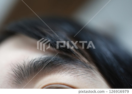 Eyebrows of a woman in her 20s that have not been groomed for a long time: Dark and thick eyebrow lines 126916979