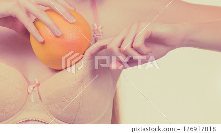 Woman small boobs puts big fruit in her bra Woman small boobs puts big fruit in her bra 126917018