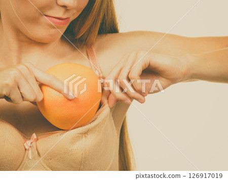 Woman small boobs puts big fruit in her bra 126917019