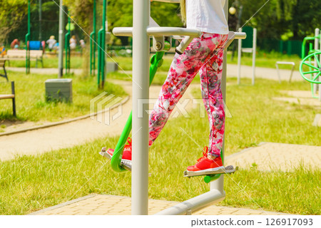 Girl doing legs exercises in outdoor gym 126917093