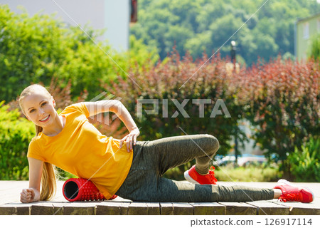Girl doing exercises outdoor, using roller Girl doing exercises outdoor, using roller 126917114