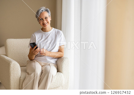 A mature elderly, well-groomed, beautiful woman pensioner with gray hair writes a message A mature elderly, well-groomed, beautiful woman pensioner with gray hair writes a message 126917432