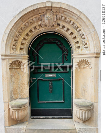 Ancient stone arch with wooden entrance door. Architecture of Europe. 126918127