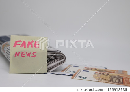 An envelope with money lies on a newspaper with fake news. An envelope with money lies on a newspaper with fake news. 126918786