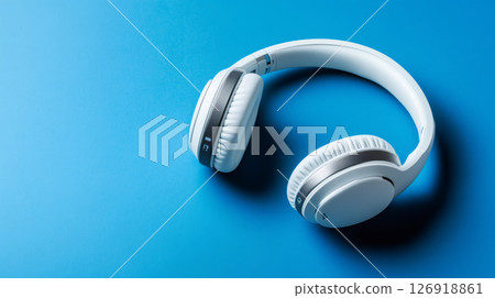 White Wireless Headphones Lying on Vibrant Blue Background 126918861