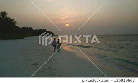 Couple walking on a tropical beach at sunset in maldives 126919608