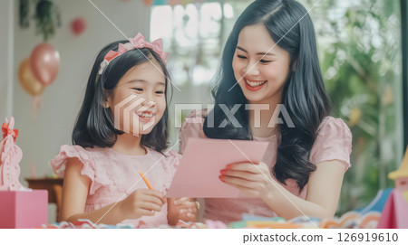 Little girl giving greeting card to her mother celebrating mother's day 126919610