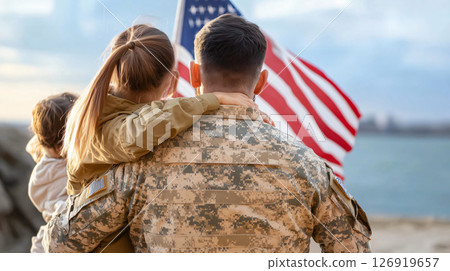 Military family embracing while looking at american flag 126919657