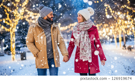 Happy couple holding hands and walking on a snowy christmas market 126919674