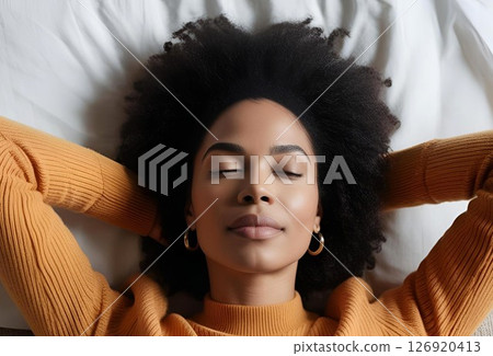 Beautiful black woman lying in bed with her eyes closed 126920413