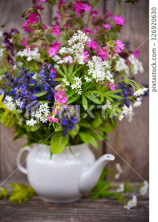 Bouquet of colorful wildflowers on an old wooden background. Still life with wild flowers Bouquet of colorful wildflowers on an old wooden background. Still life with wild flowers 126920630