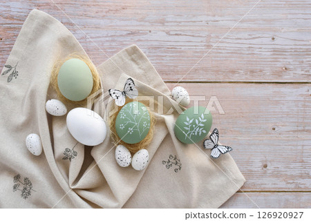 Stylish decorated easter eggs on linen cloth on a light wooden background. Top view. Stylish decorated easter eggs on linen cloth on a light wooden background. Top view. 126920927