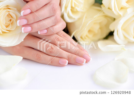 Hands of a woman with beautiful french manicure and white roses Hands of a woman with beautiful french manicure and white roses 126920948