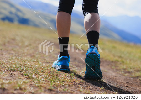 Fitness woman runner running at high altitude grassland mountain top road Fitness woman runner running at high altitude grassland mountain top road 126921020