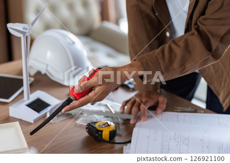 ESG Principles in Action. Architect measuring dimensions for a sustainable project. ESG Principles in Action. Architect measuring dimensions for a sustainable project. 126921100