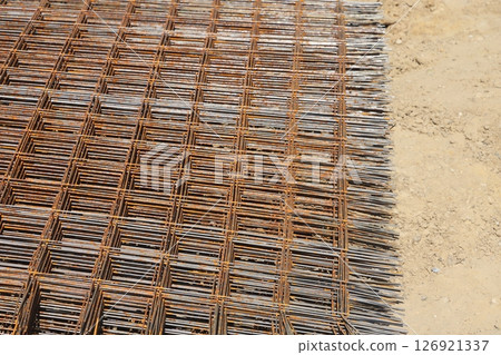 Stack of rusty wire mesh at a construction site. Metal building grate. Stack of rusty wire mesh at a construction site. Metal building grate. 126921337