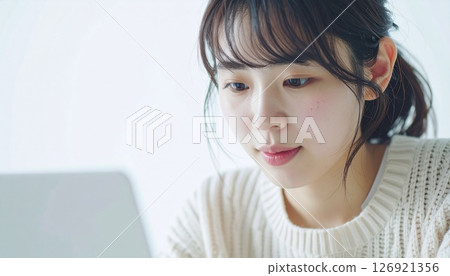 A young Japanese woman works naturally on a PC 126921356