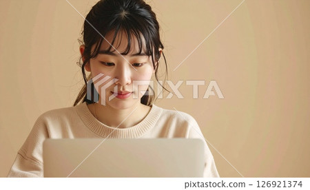 A Japanese woman in casual clothes working on a PC 126921374