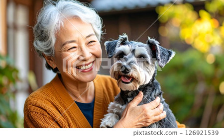 一位慈祥的祖母撫摸迷你雪納瑞犬的感人肖像 126921539