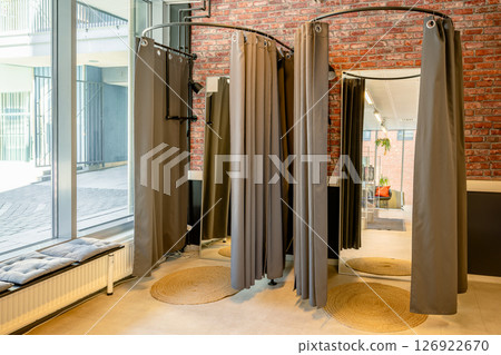 Modern fitting room with curtains and mirrors in stylish interior space Modern fitting room with curtains and mirrors in stylish interior space 126922670