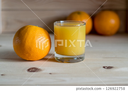 In the foreground is a glass with orange juice and one orange 126922758