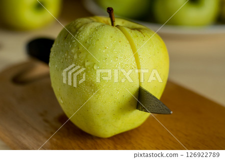 A beautiful green apple with a knife 126922789