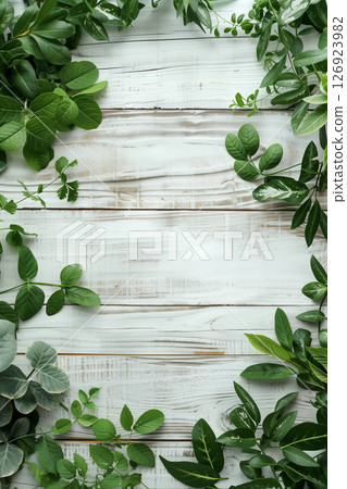 Flat lay arrangement of assorted green herbs on white wooden surface for culinary use 126923982