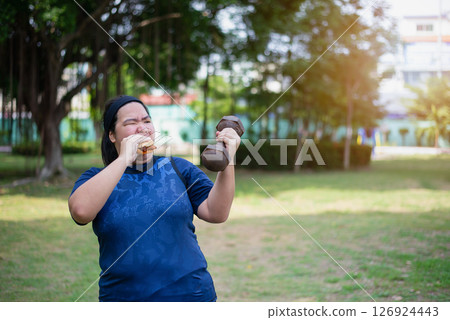Chinese women eat hamburgers and raise dumbbells 126924443