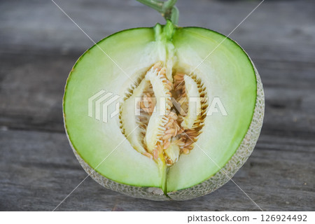 Half of melon on the wood background 126924492