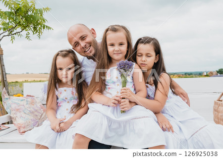 The father spends time with his three daughters in the lavender field The father spends time with his three daughters in the lavender field 126925038