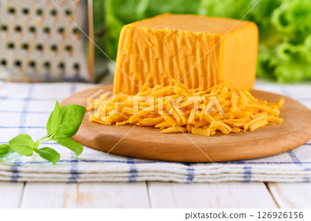 grated cheddar cheese on a white wooden table, copy space for text. 126926156