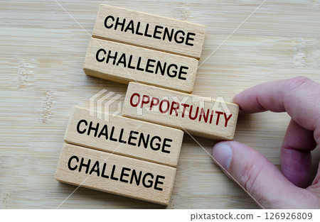 Challenges and Opportunities Coexist, a reminder that every challenge carries potential opportunities, shown through opposing wooden block messages 126926809