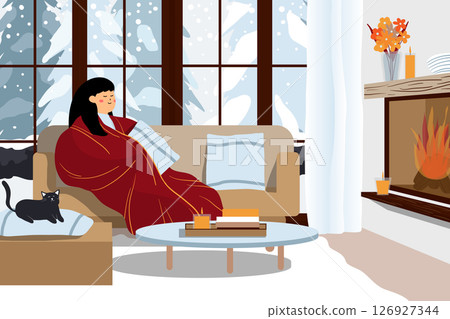 Woman wrapped in a blanket by the fireplace in a cozy room. 126927344