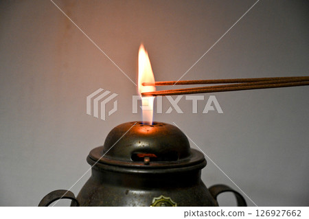 油燈火焰點燃香的特寫 油燈火焰點燃香的特寫 126927662