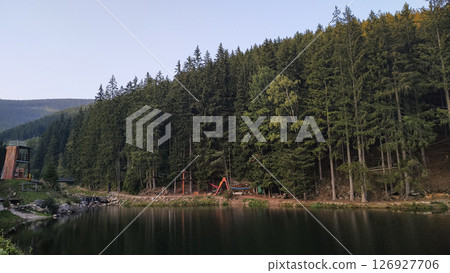 Lake reflecting pine forest and adventure park near snezka mountain in czechia in august 126927706